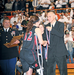 SAVANNAH SWENSON, injured during the second night of play, receives her medal.