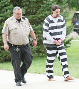 MATTHEW NOVAK is brought into the courthouse Tuesday afternoon by Sanborn County Deputy Jason Coenen.
