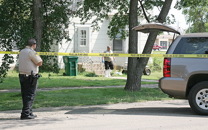  Sanborn County Sheriff’s Deputy Naif Alatta guards the perimeter of the crime scene as Deputy Jason Coenen exits the house. Jennifer Gibson, 26, of Woonsocket was killed in the home Wednesday morning, Aug. 31.