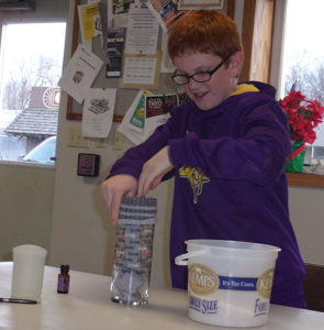 Michael Hoffman demonstrating how to make a heat warmer with rice, a recycled basketball sock and a fragrance oil.