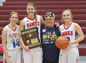 THE SENIORS leading the Blackhawk team pose with the loot from their Region win and Lynette Kingsbury in the place of her daughter and their former classmate, Tanna Kingsbury, who passed away at the start of their sophomore year to a rare form of juvenile bone cancer.