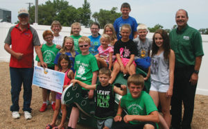 Director Butch Morrison (left) and General Manager Ken Schlimgen (right) present the check to the 4-H Blue Group members and group leaderJanet Maeschen.